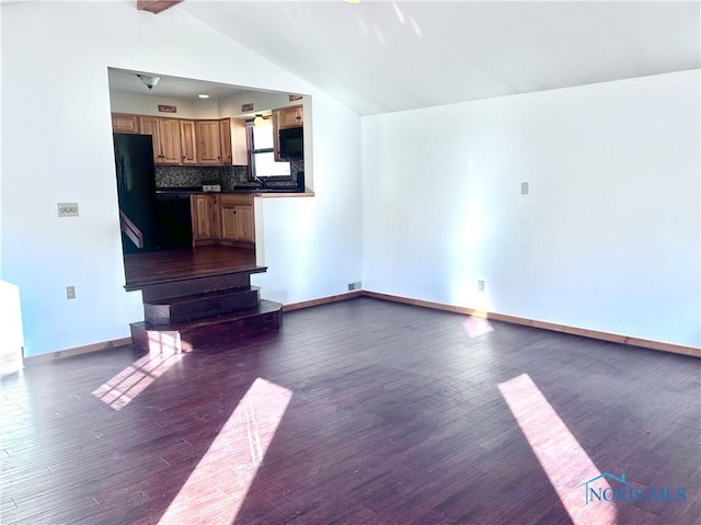 unfurnished living room featuring vaulted ceiling with beams and dark hardwood / wood-style floors