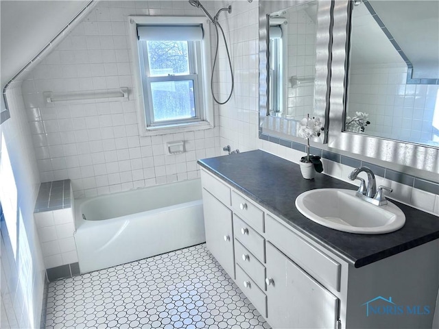 bathroom with vanity, tile walls, and backsplash