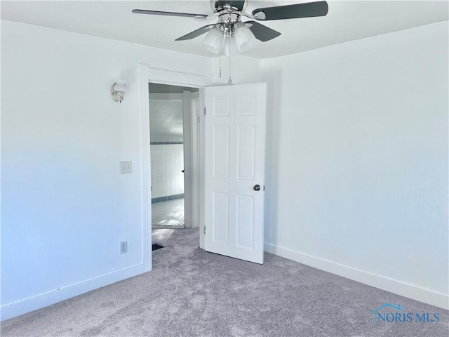 carpeted spare room with ceiling fan