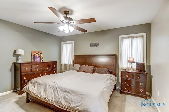 carpeted bedroom featuring ceiling fan and multiple windows