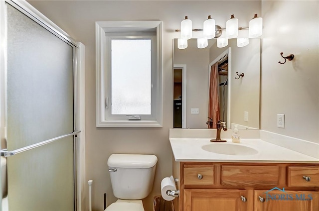 bathroom featuring vanity, toilet, and walk in shower