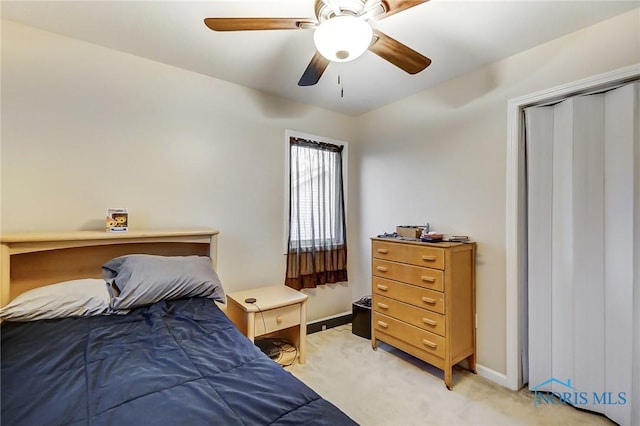 bedroom with a closet, light colored carpet, and ceiling fan