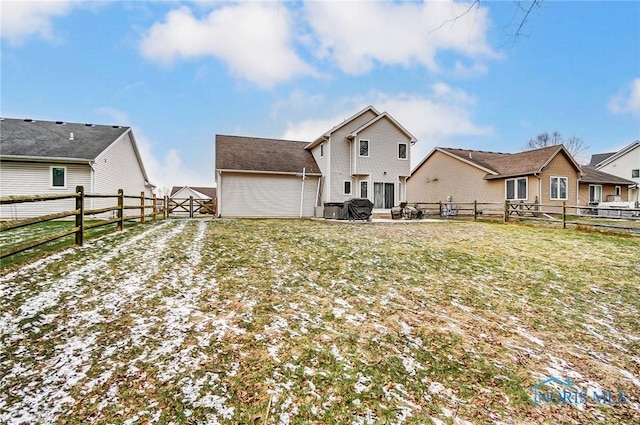 rear view of property featuring cooling unit and a lawn