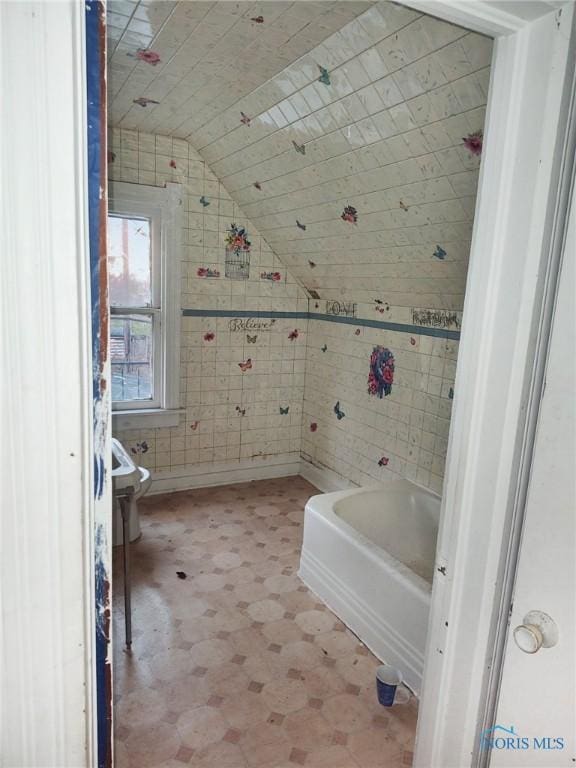 bathroom featuring a bathing tub, toilet, lofted ceiling, and wood ceiling