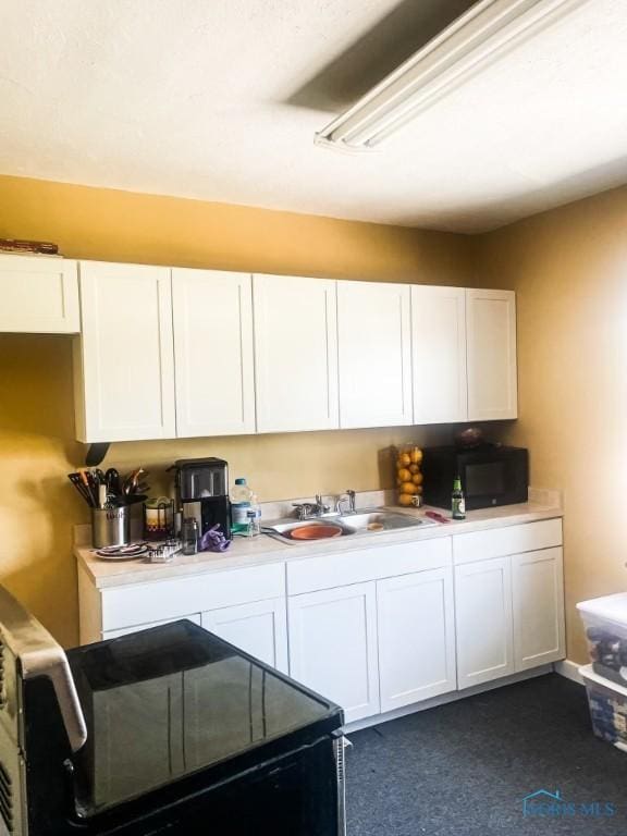 kitchen featuring white cabinetry, sink, and black appliances