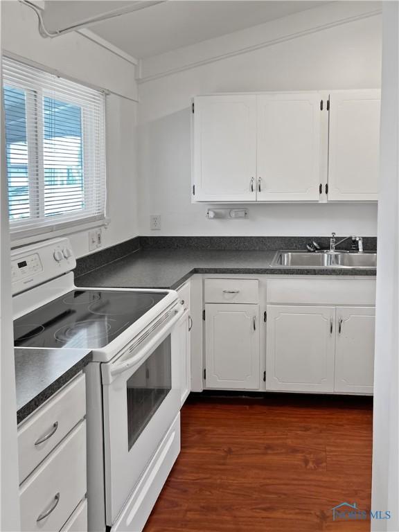 kitchen featuring dark hardwood / wood-style flooring, sink, white cabinets, and white electric range oven