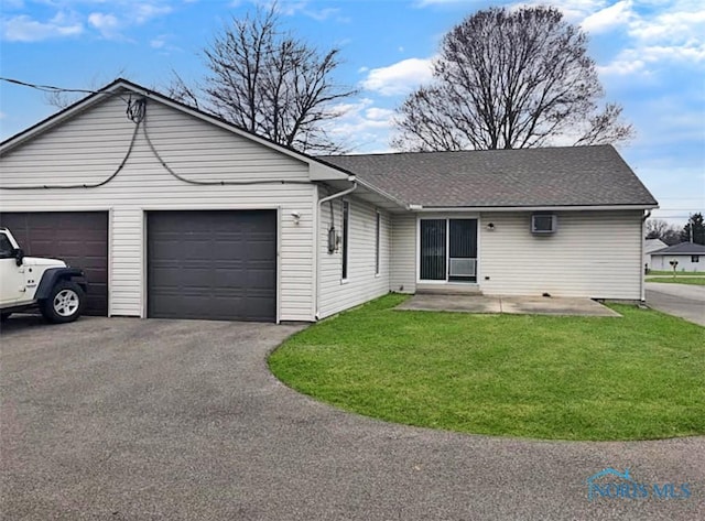 single story home with a garage and a front lawn