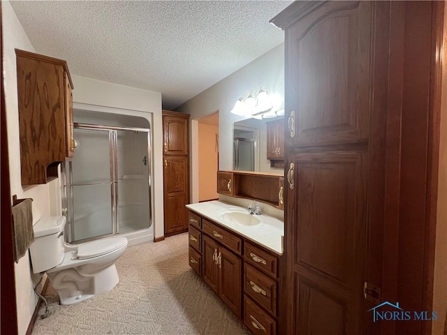 bathroom with vanity, a textured ceiling, toilet, and walk in shower