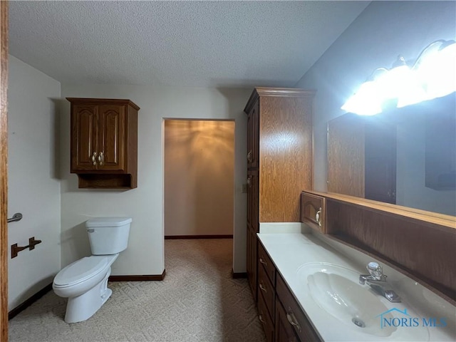 bathroom with vanity, toilet, and a textured ceiling