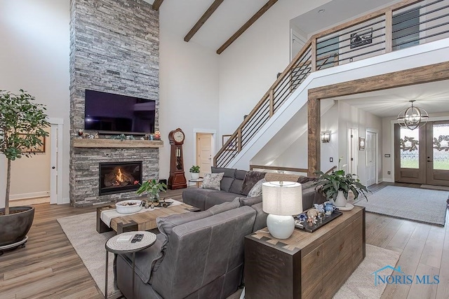 living room with beamed ceiling, hardwood / wood-style floors, and high vaulted ceiling