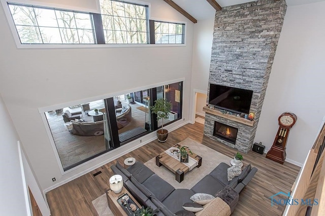 living room with beamed ceiling, a fireplace, high vaulted ceiling, and hardwood / wood-style floors