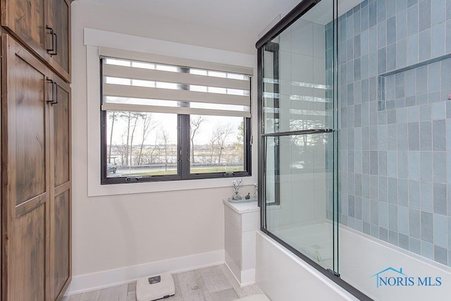 bathroom featuring shower / bath combination with glass door