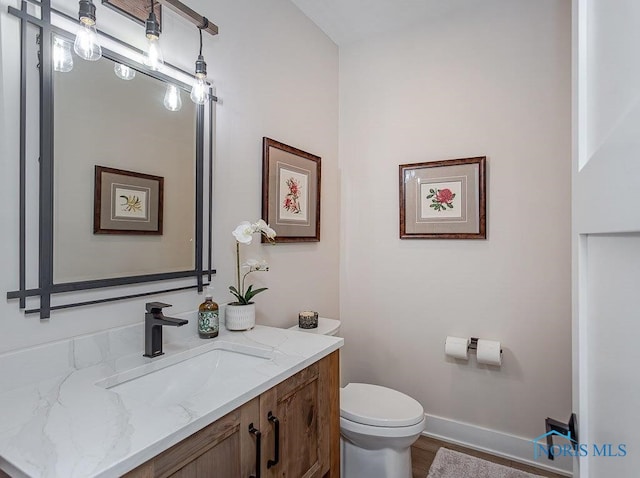 bathroom featuring hardwood / wood-style floors, vanity, and toilet