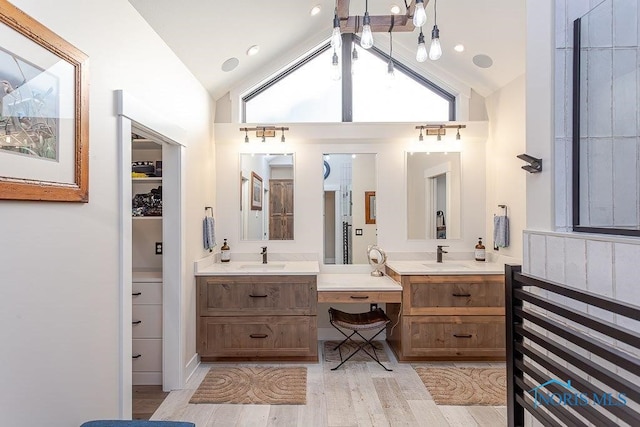 bathroom featuring hardwood / wood-style floors, vanity, and vaulted ceiling