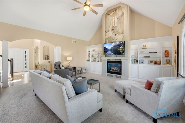 living room with ceiling fan, light colored carpet, ornate columns, and high vaulted ceiling