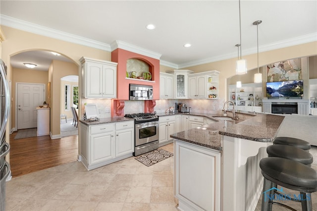 kitchen featuring dark stone countertops, white cabinetry, and appliances with stainless steel finishes