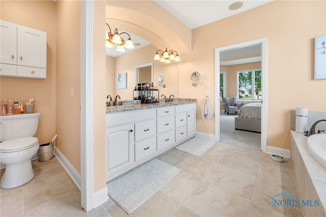 bathroom with tile patterned flooring, vanity, toilet, and tiled tub