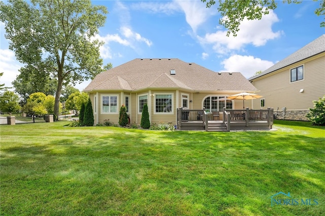 rear view of house with a lawn and a deck