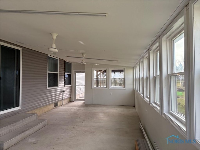 unfurnished sunroom with ceiling fan and vaulted ceiling