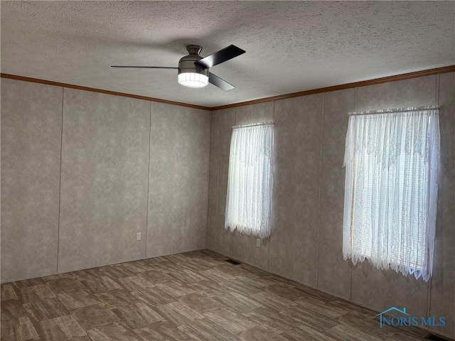 unfurnished room with ceiling fan and a textured ceiling