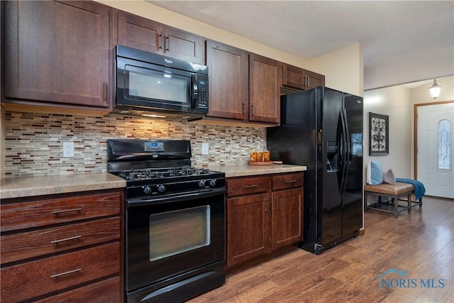 kitchen featuring black appliances, dark brown cabinets, light hardwood / wood-style floors, and backsplash