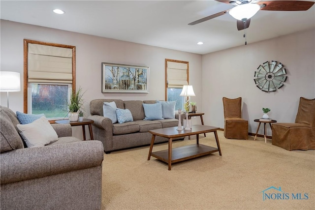 carpeted living room featuring ceiling fan and a healthy amount of sunlight