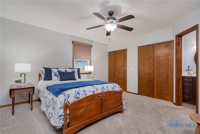 carpeted bedroom with ceiling fan and multiple closets