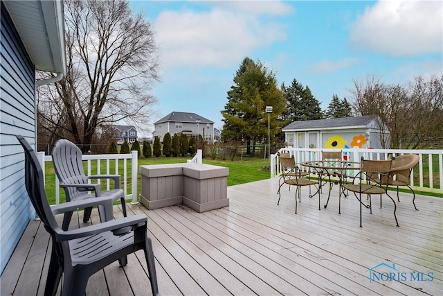 wooden deck with a yard and an outdoor structure