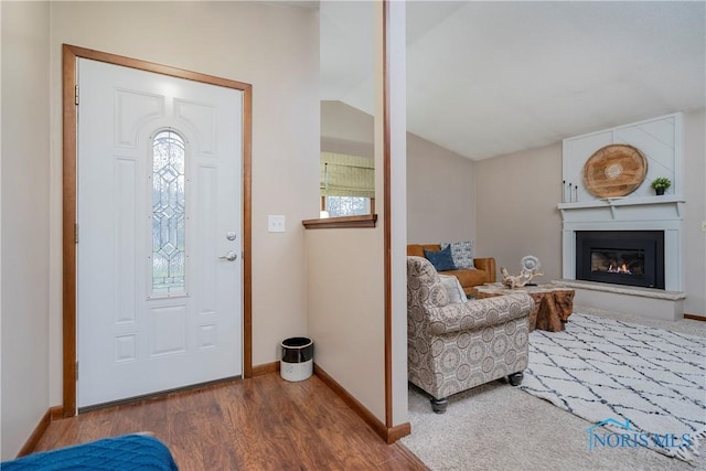 foyer with wood-type flooring and lofted ceiling