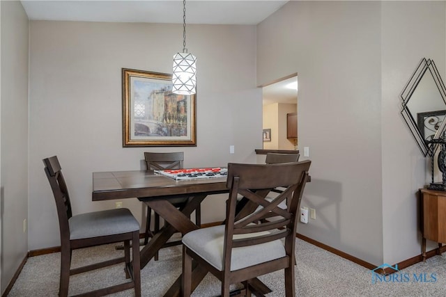 dining area featuring light carpet and lofted ceiling