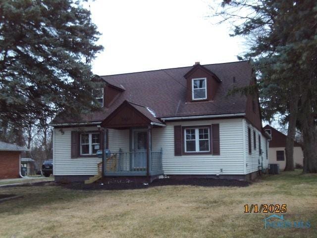 new england style home with central air condition unit and a front yard