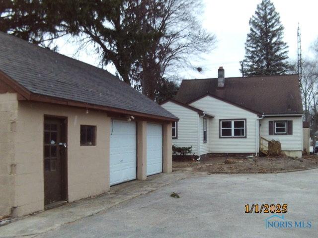 rear view of house featuring a garage and an outdoor structure