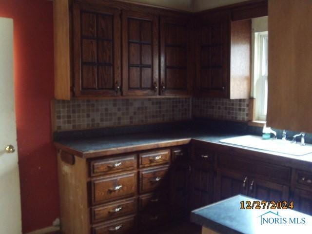 kitchen featuring decorative backsplash, sink, and dark brown cabinets