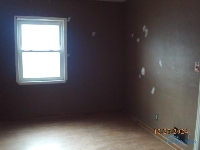 spare room featuring hardwood / wood-style flooring and plenty of natural light