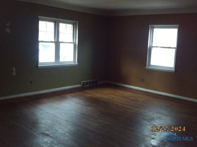 unfurnished room featuring dark hardwood / wood-style flooring and a healthy amount of sunlight