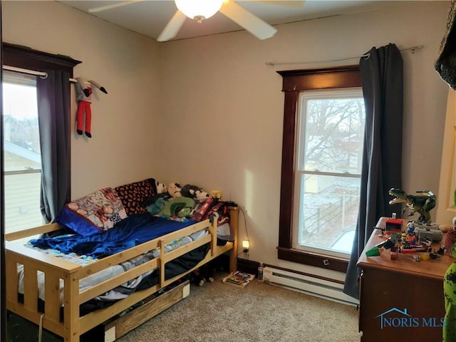 carpeted bedroom featuring baseboard heating and ceiling fan