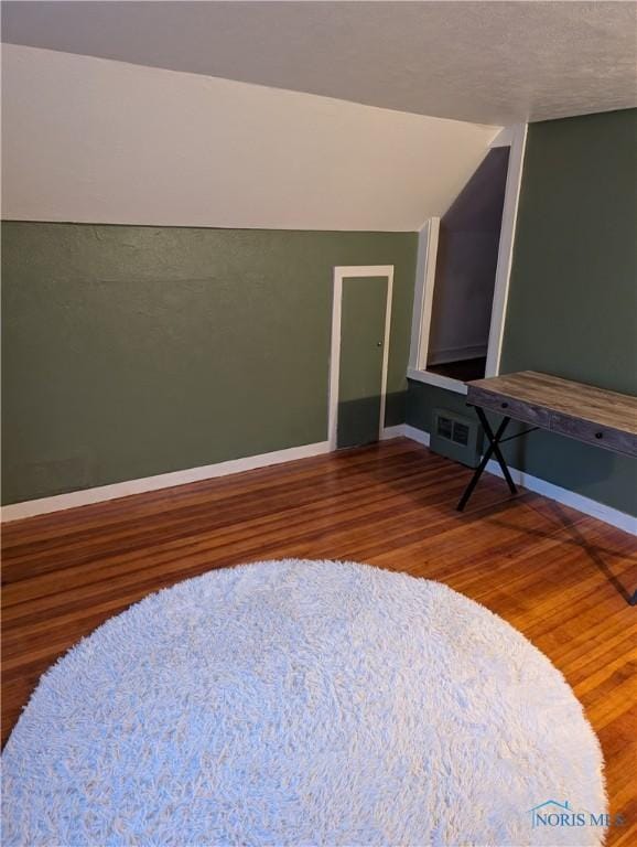 interior space featuring hardwood / wood-style floors and lofted ceiling