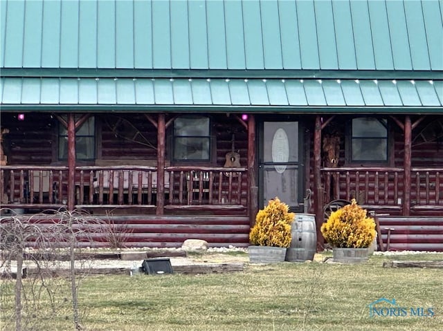 view of front of property featuring a porch, a standing seam roof, and log exterior