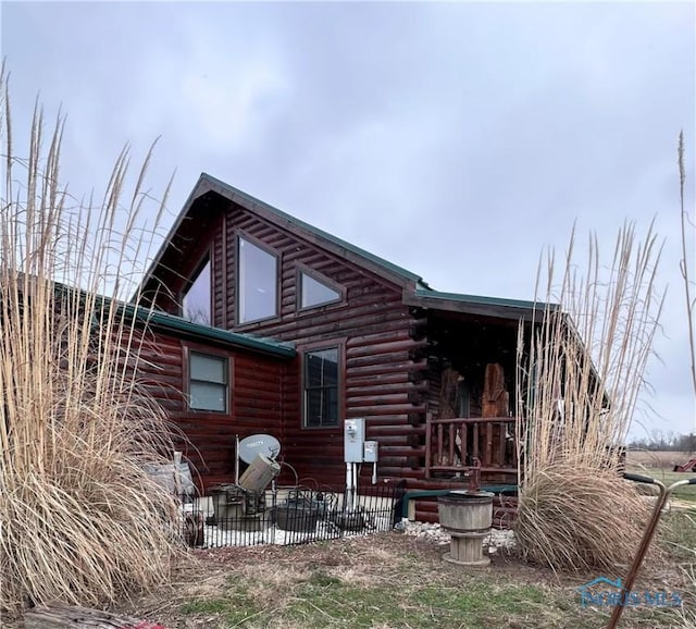 view of home's exterior featuring a patio and log siding