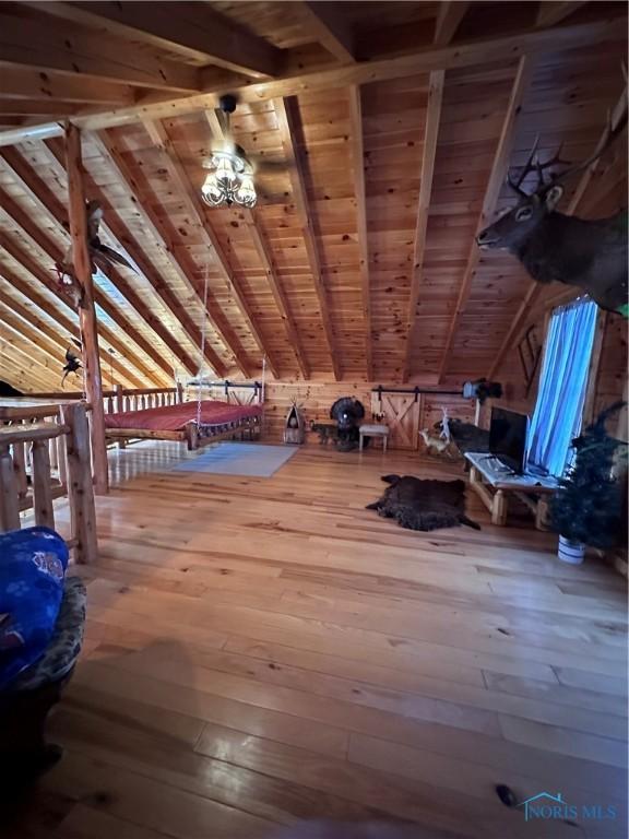 unfurnished bedroom with vaulted ceiling with beams, hardwood / wood-style flooring, and wooden ceiling