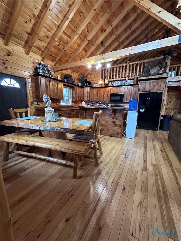 dining space with high vaulted ceiling, wood ceiling, beam ceiling, and light wood-style flooring