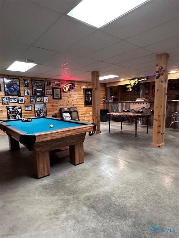 playroom with pool table, a drop ceiling, finished concrete floors, and wooden walls