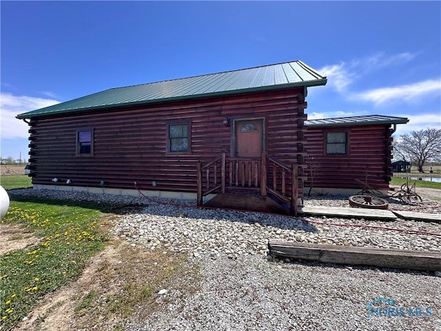 exterior space featuring metal roof and log siding