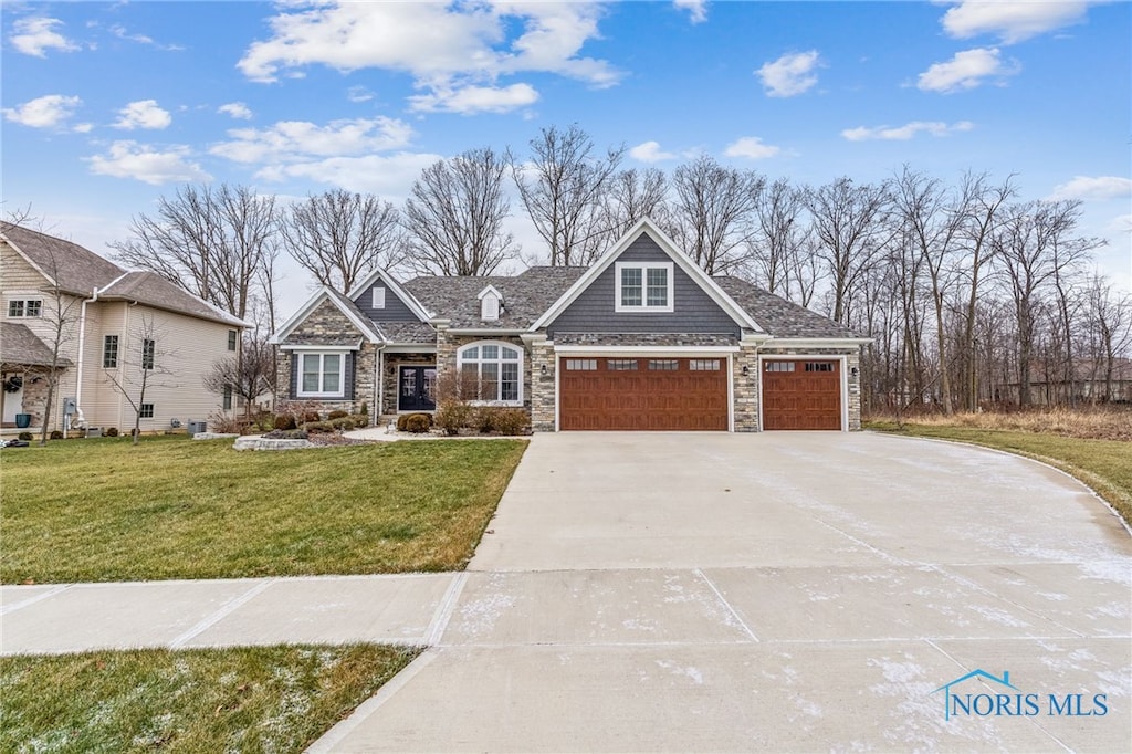 view of front of property featuring a front yard and a garage