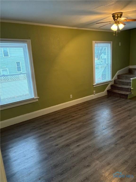 empty room with crown molding, ceiling fan, and dark hardwood / wood-style floors