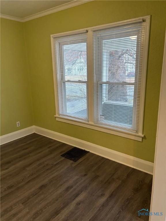 unfurnished room featuring dark hardwood / wood-style flooring and ornamental molding