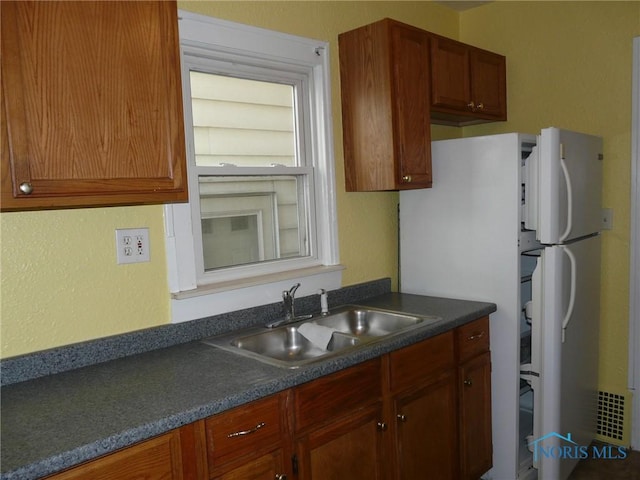 kitchen featuring white fridge and sink