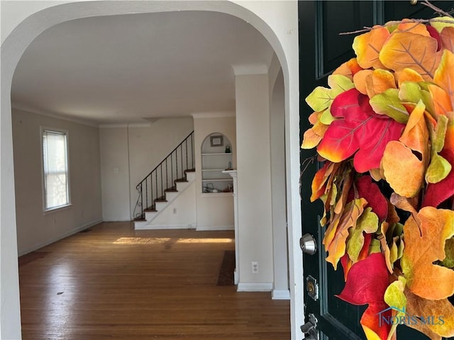 entryway with dark hardwood / wood-style flooring and ornamental molding