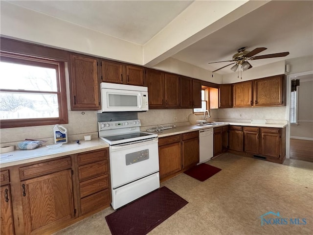 kitchen with sink, white appliances, decorative backsplash, and ceiling fan