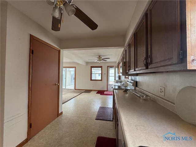 kitchen featuring ceiling fan and dark brown cabinetry